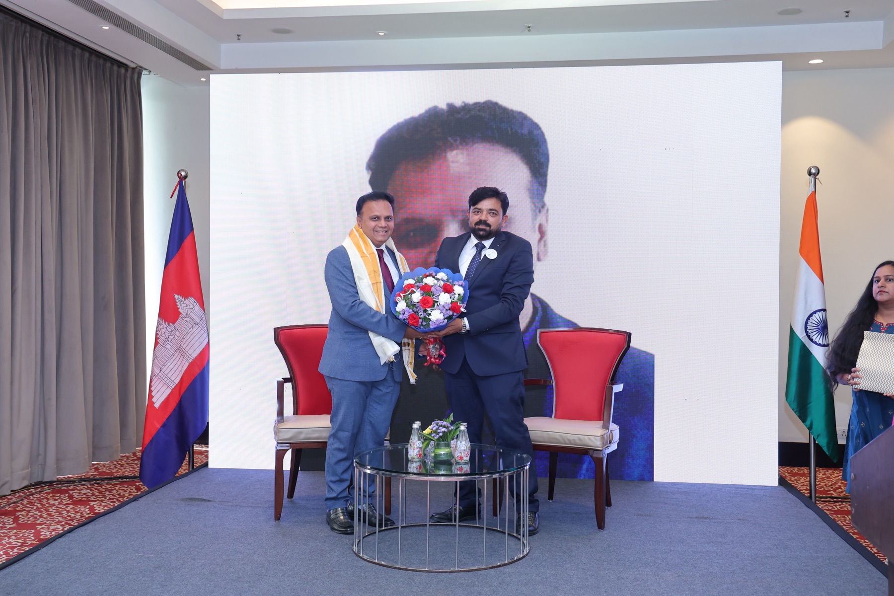 A speaker being felicitated on stage at the forum